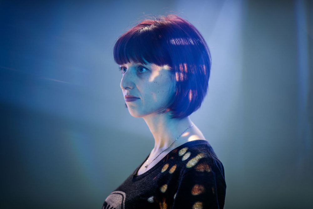 Artistic profile shot with dramatic blue and red lighting.