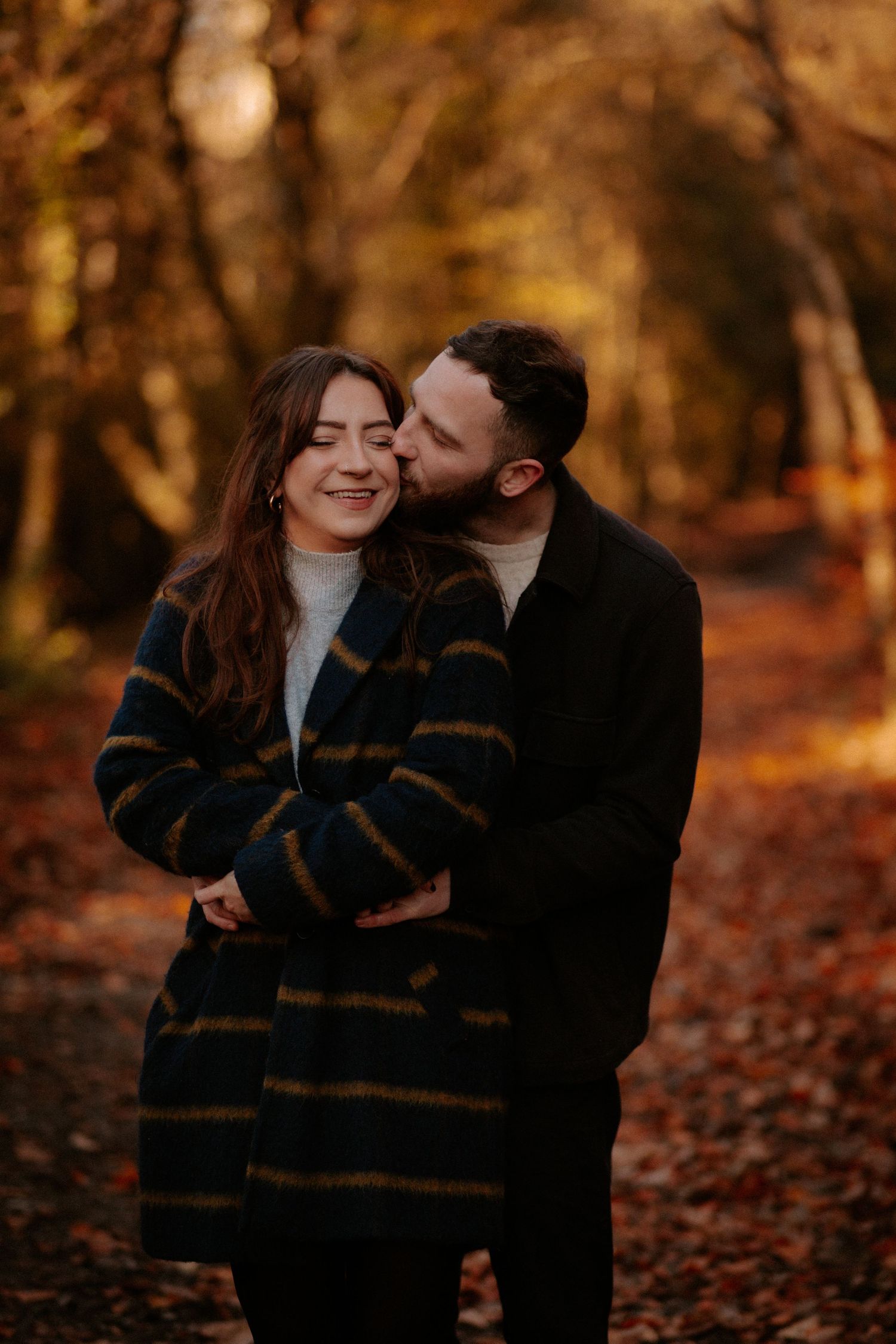 A couple walking hand in hand through a misty field during a black and white photoshoot.
