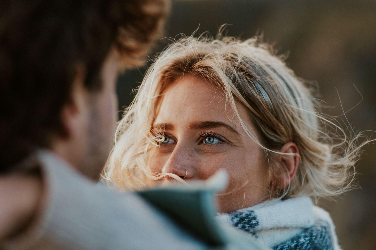 A tender close-up portrait shows a couple gazing at each other in golden light.