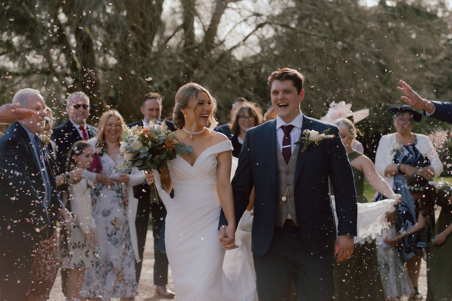 Wedding guests shower the newlyweds with confetti during an outdoor celebration at Eastington Park.