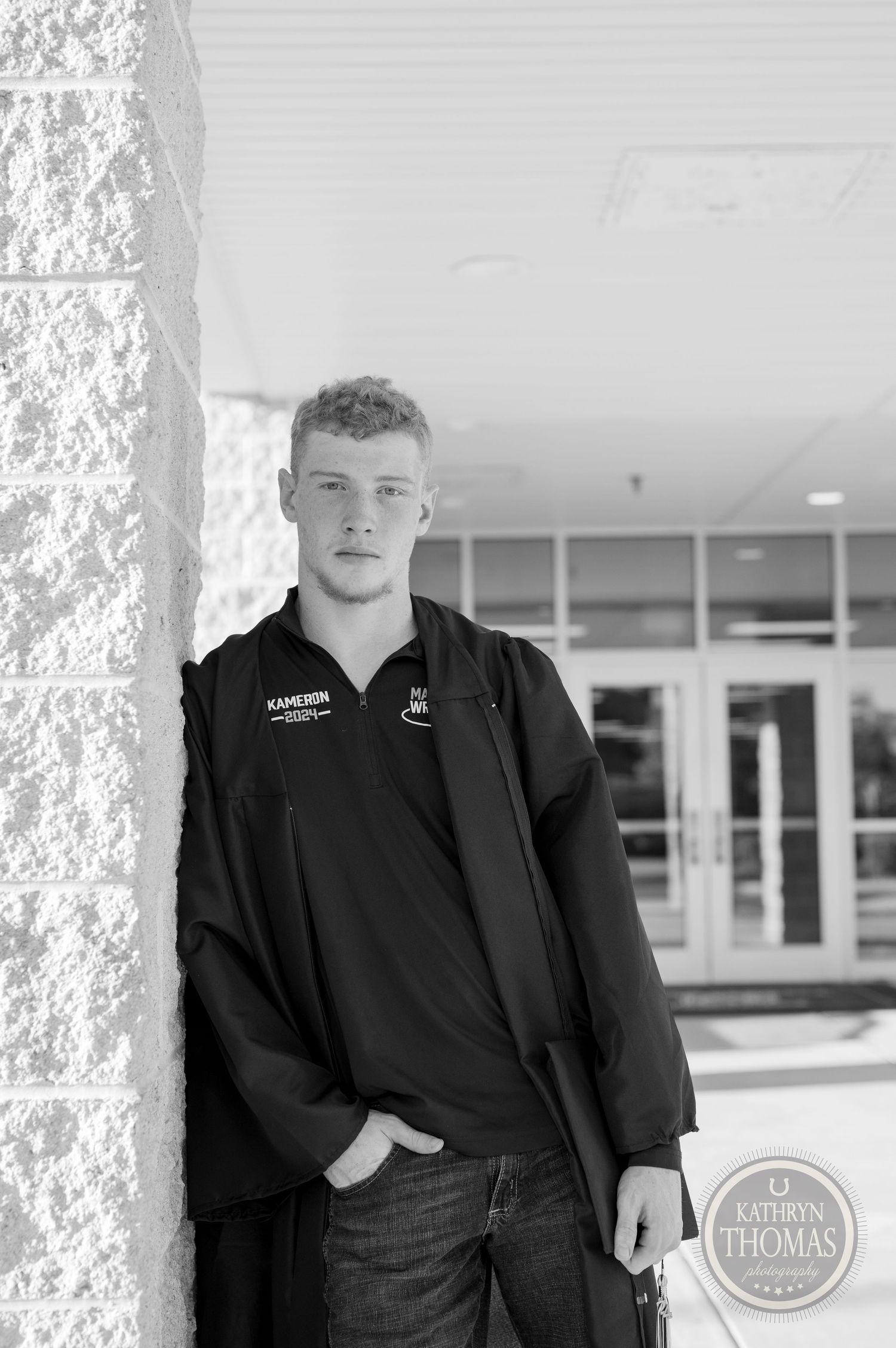 Black and white portrait of student in casual attire against stone column.