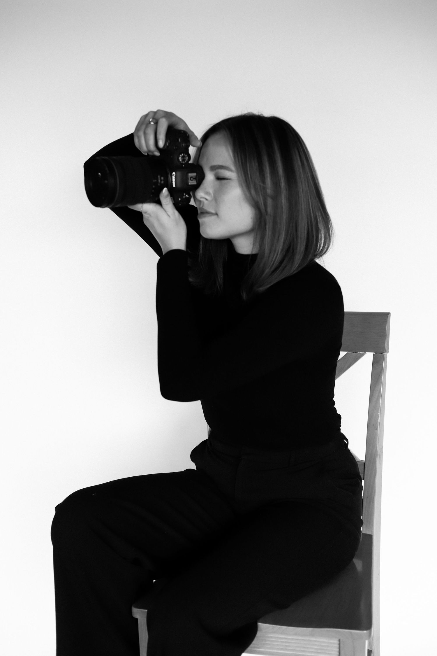 Silhouette of a photographer taking pictures against white background.