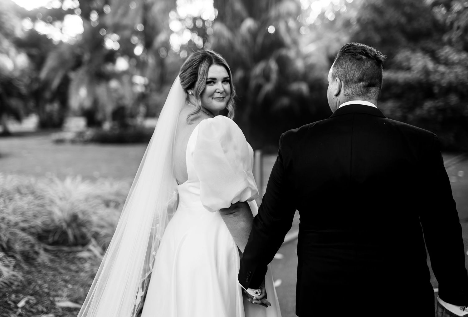 Wedding ceremony black and white candid moments captured in an outdoor garden setting.