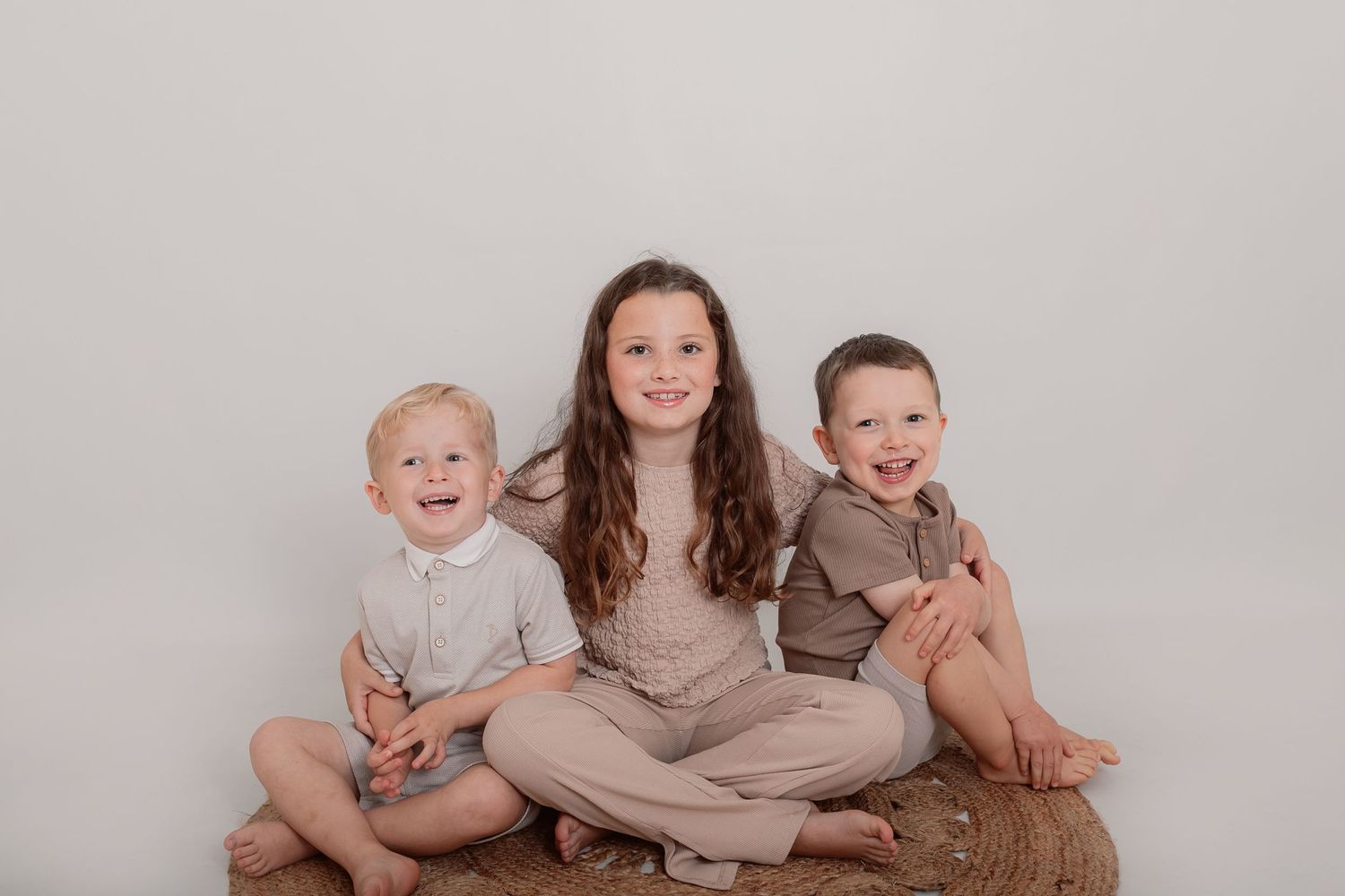Casual family portrait with siblings in neutral coloured clothing against white background. Photographer. Hull. East Yorkshire. Photography