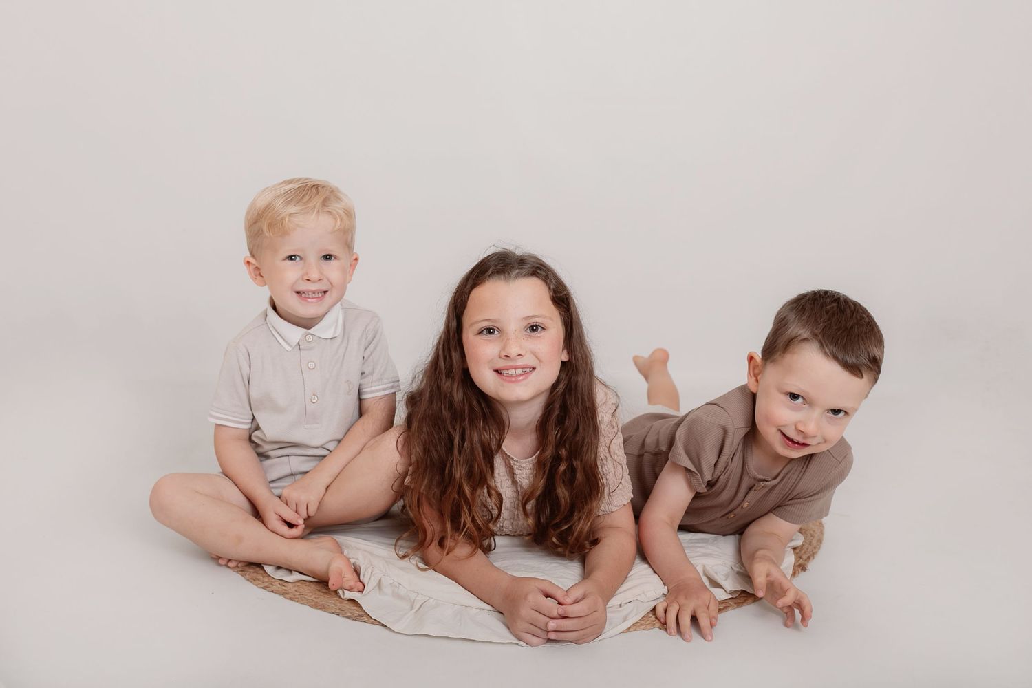 Studio photography session with family members lounging on floor in earth-toned outfits. Photographer. Hull. East Yorkshire. Photography