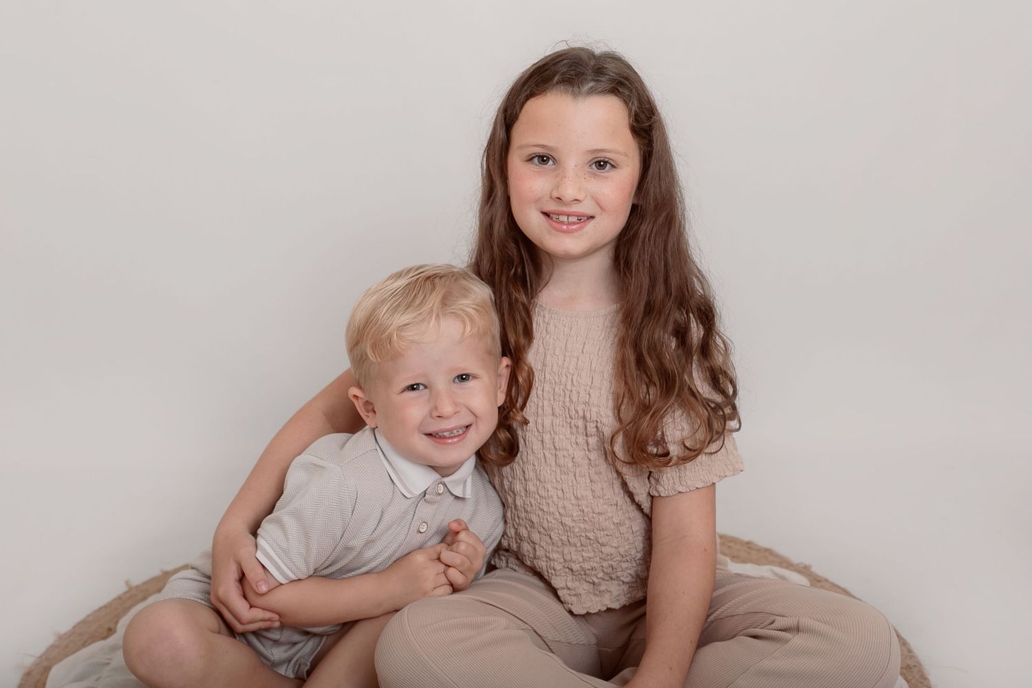 Siblings posing together in coordinated neutral outfits during professional photo shoot. Photographer. Hull. East Yorkshire. Photography