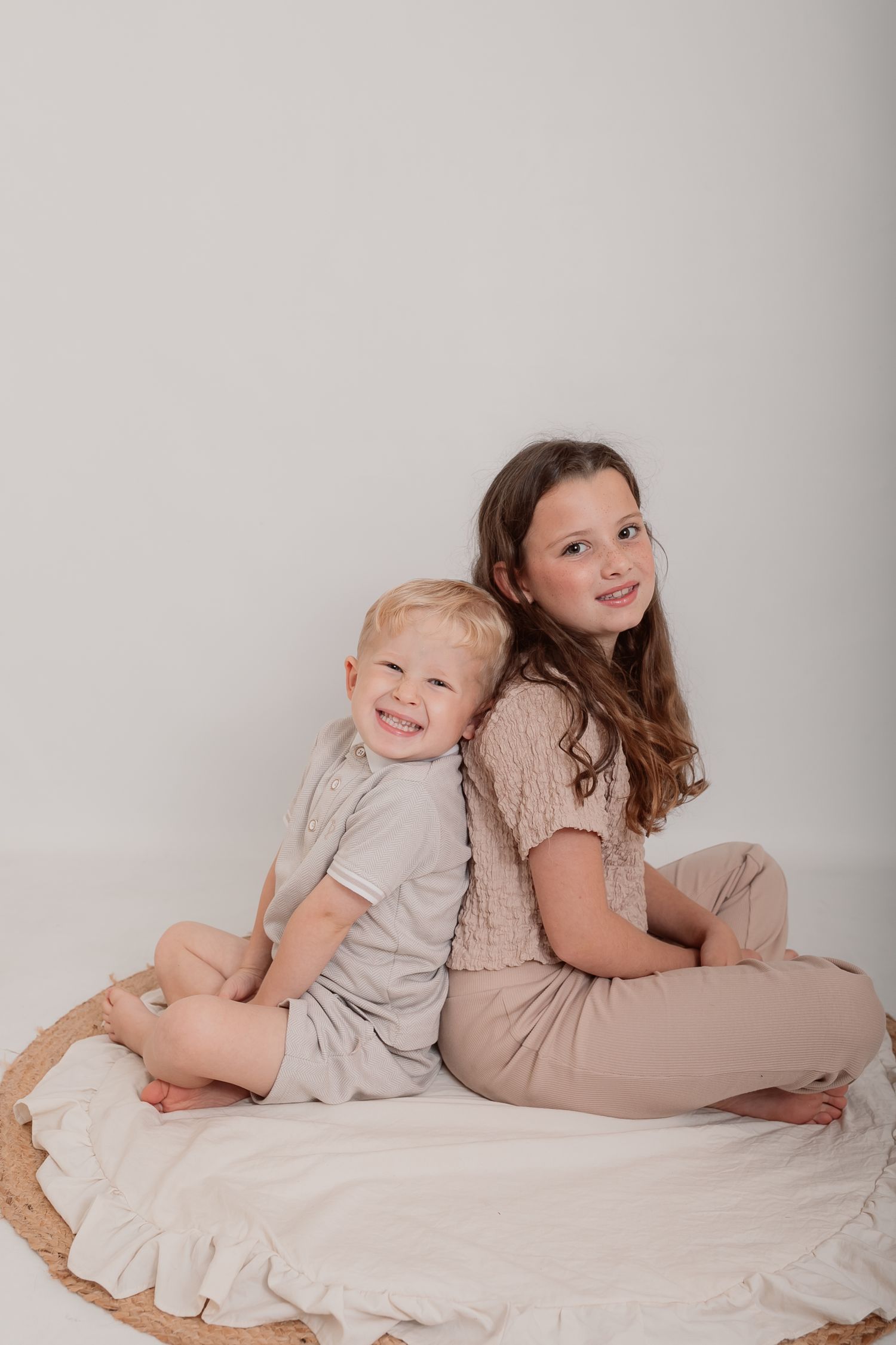 Children laying on white fabric during relaxed studio photography session. Photographer. Hull. East Yorkshire. Photography