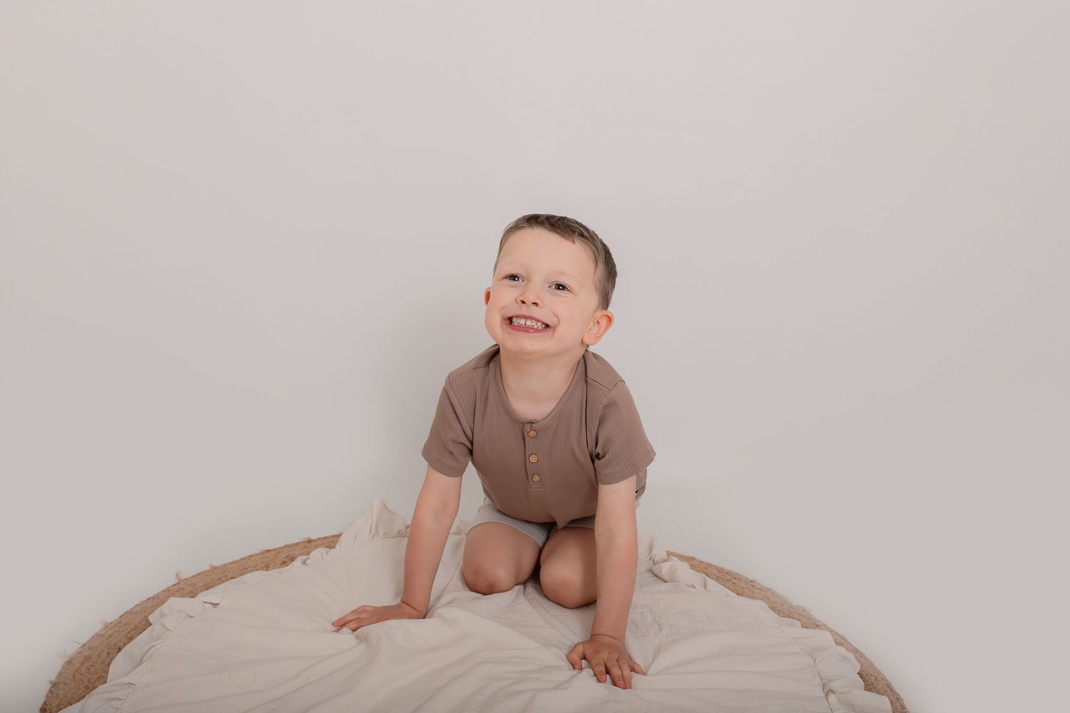 Young child crawling on white fabric during studio photo session. Photographer. Hull. East Yorkshire. Photography