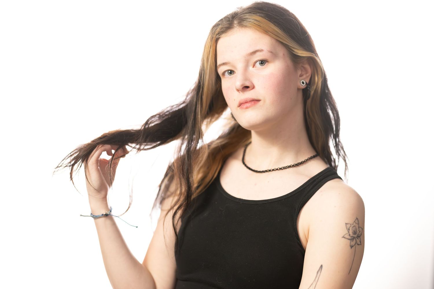 A bright portrait of Laramie wearing a dark top posing on a white background