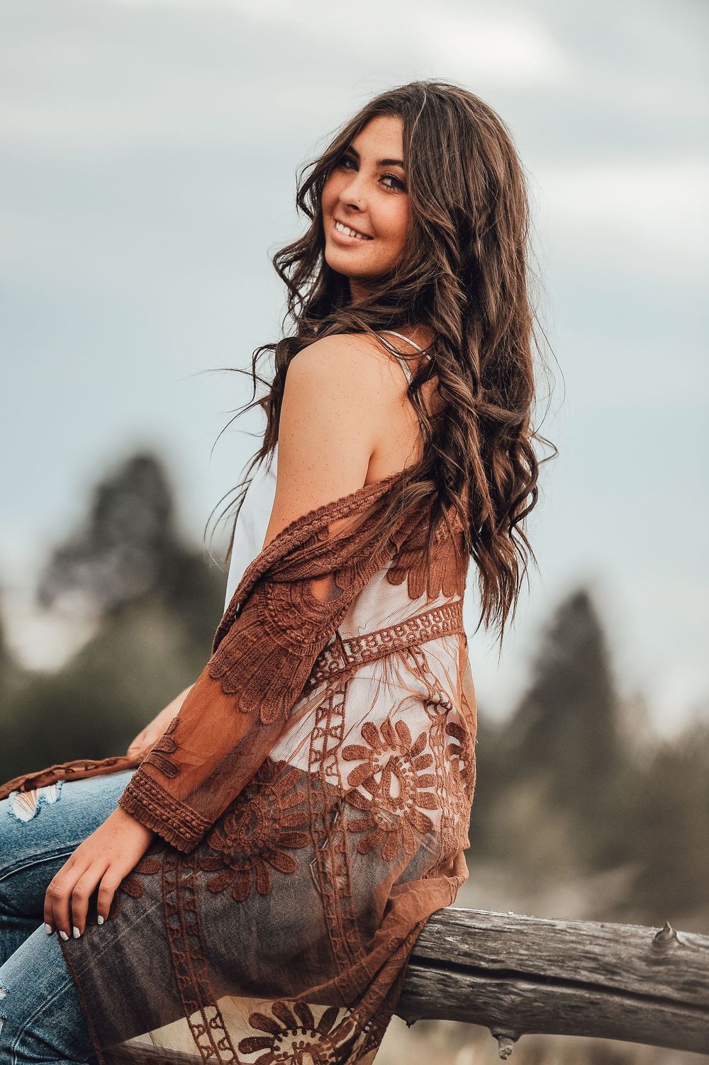 Brown lace top and denim casual portrait in natural lighting.