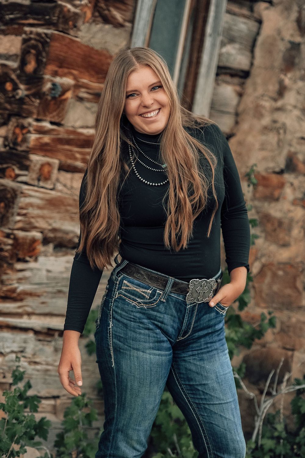Casual fashion portraits against textured stone wall in denim and black turtleneck.
