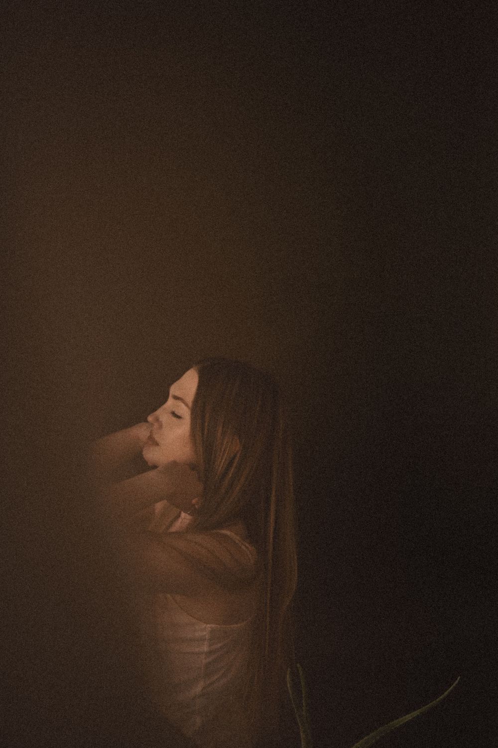 Artistic portrait with dark moody lighting creating dramatic shadows and silhouettes.