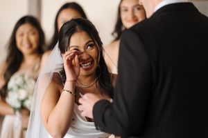 A happy couple shares a tender moment together during their wedding celebration, surrounded by loved ones.