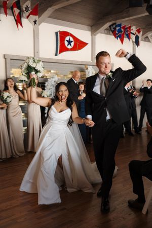 Wedding celebration with dancing guests on a hardwood floor decorated with red and blue flags.