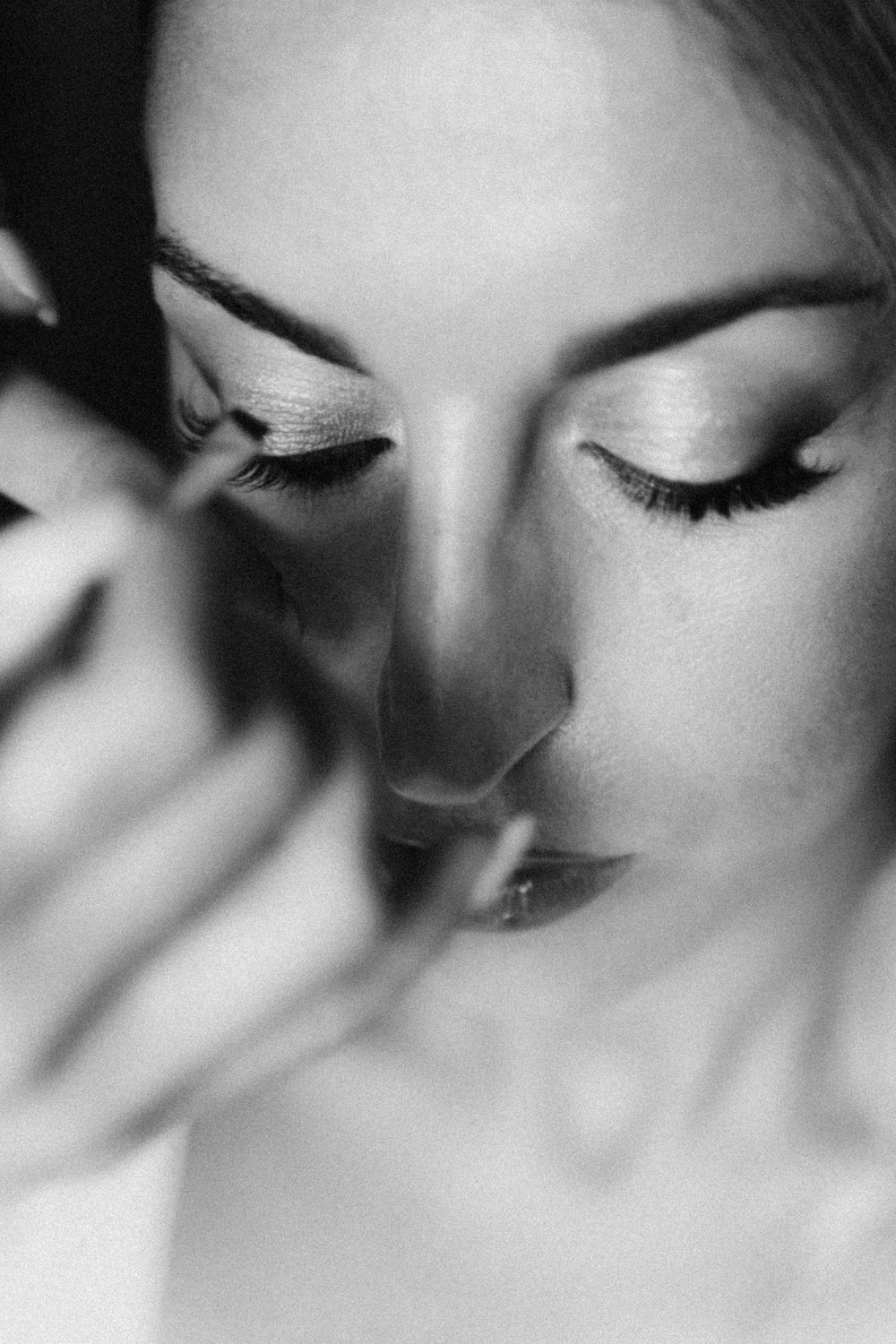 Artistic black and white macro photo showing closed eyes with long eyelashes in soft focus.
