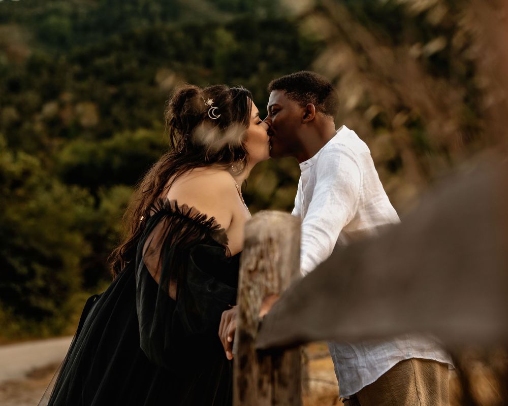 A joyful couple share intimate moments together in a forest setting during golden hour.