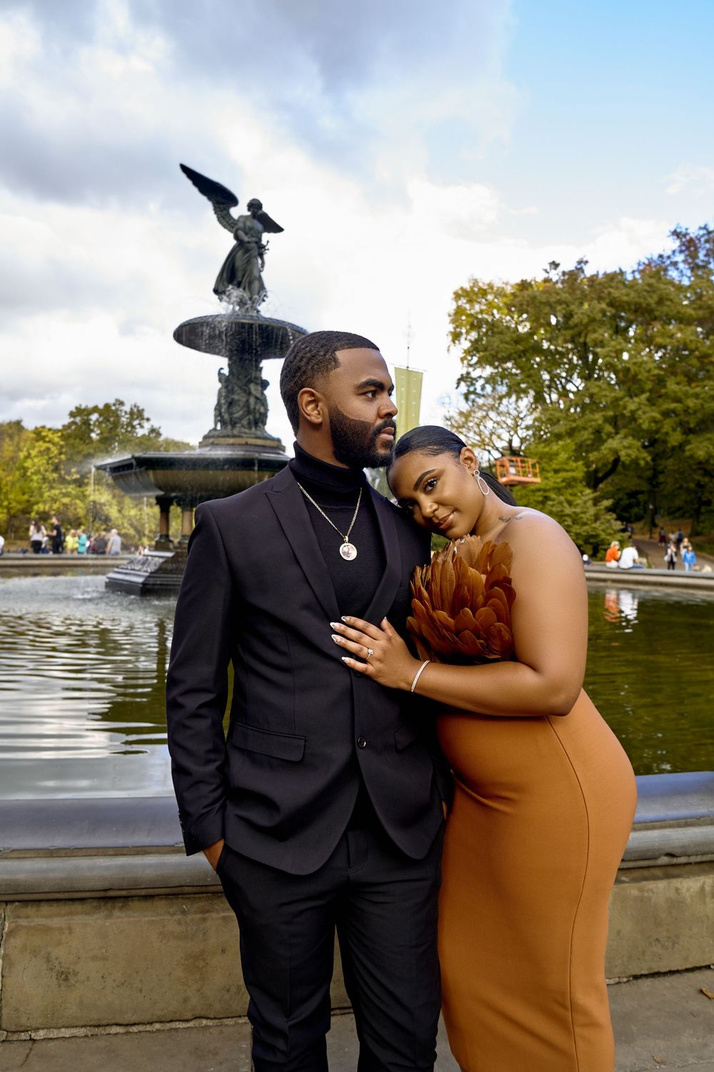 A couple poses romantically by a fountain in a park, sharing intimate moments across four connected photos. Engagement photoshoot