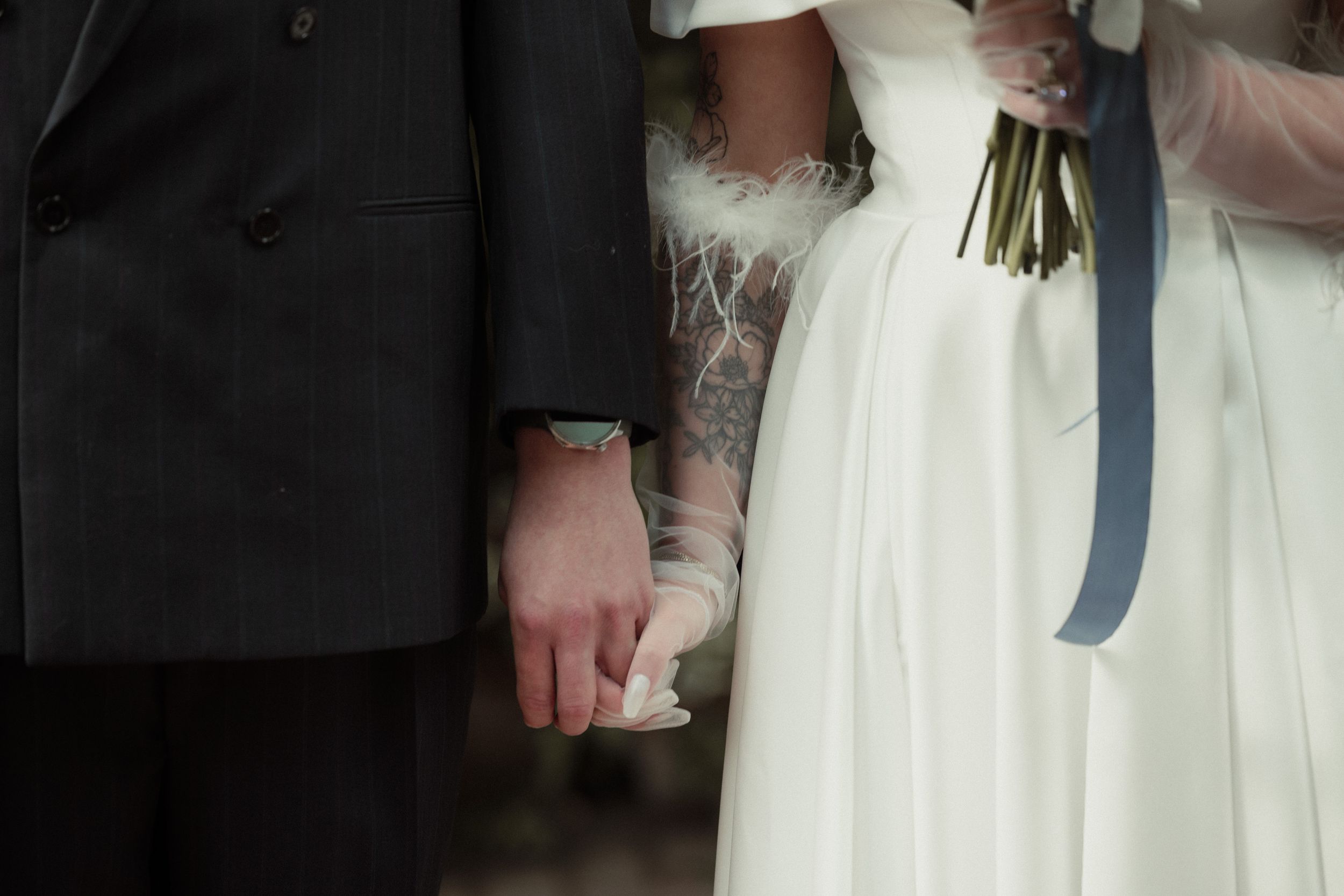 A well-dressed couple embraces during a formal dance at a wedding reception.