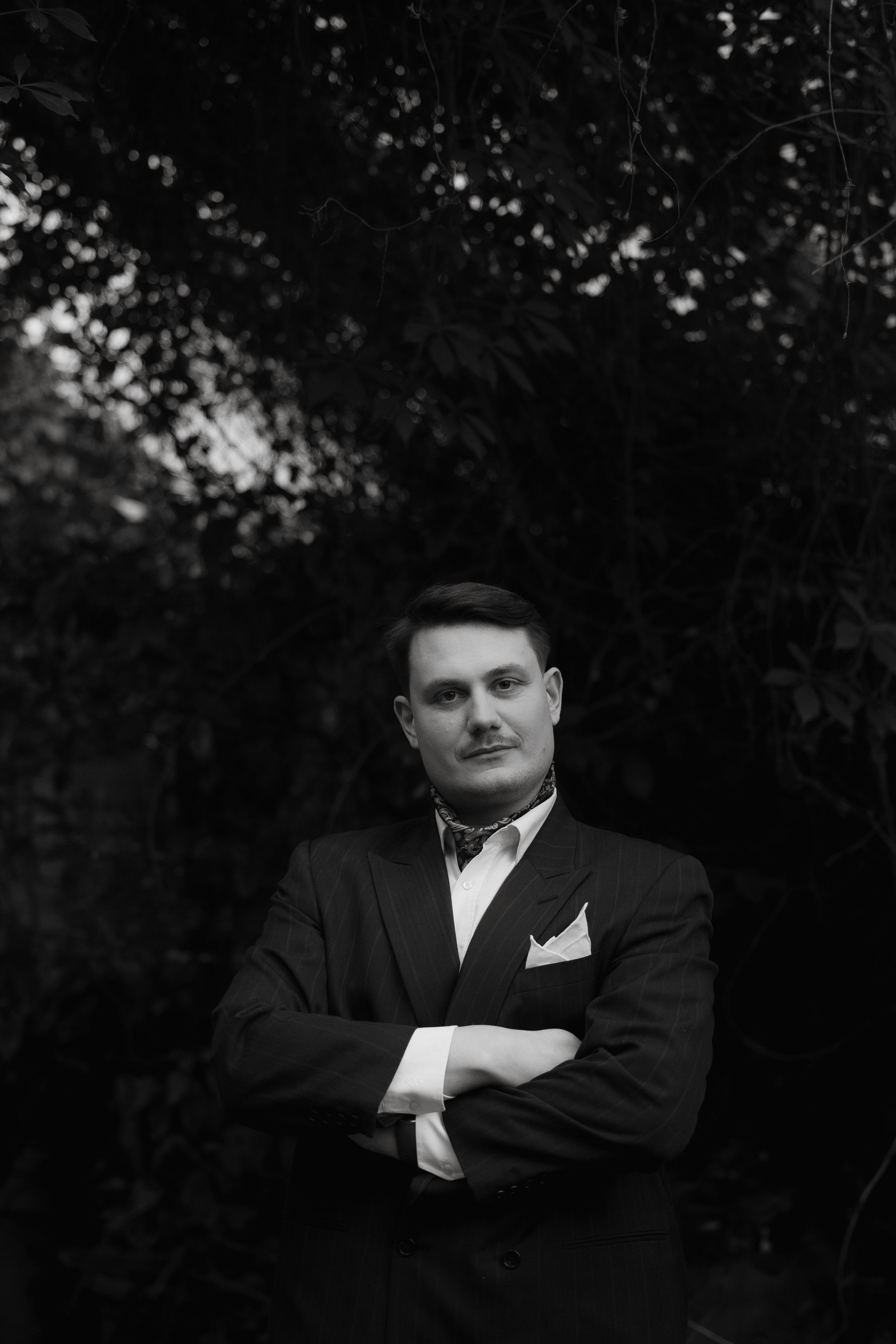 A black and white portrait photograph sequence showing moody lighting and deep shadows against a dark background.