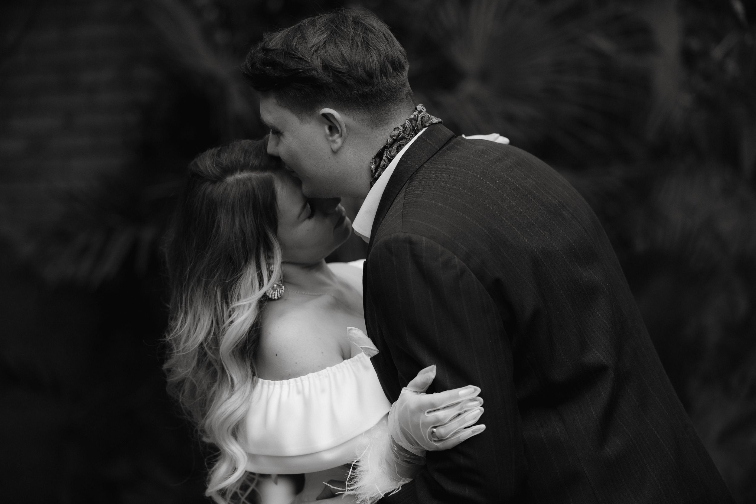 Seven black and white photos showing intimate romantic moments of a couple during a wedding celebration.