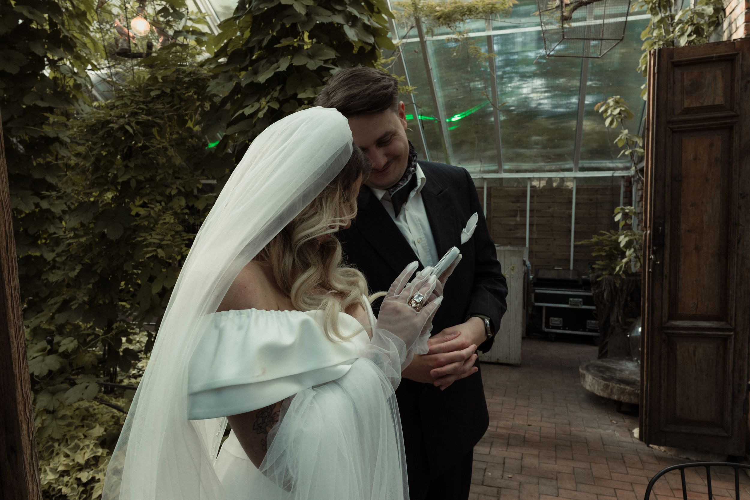Elegant wedding couple sharing a romantic moment together in a garden courtyard setting.