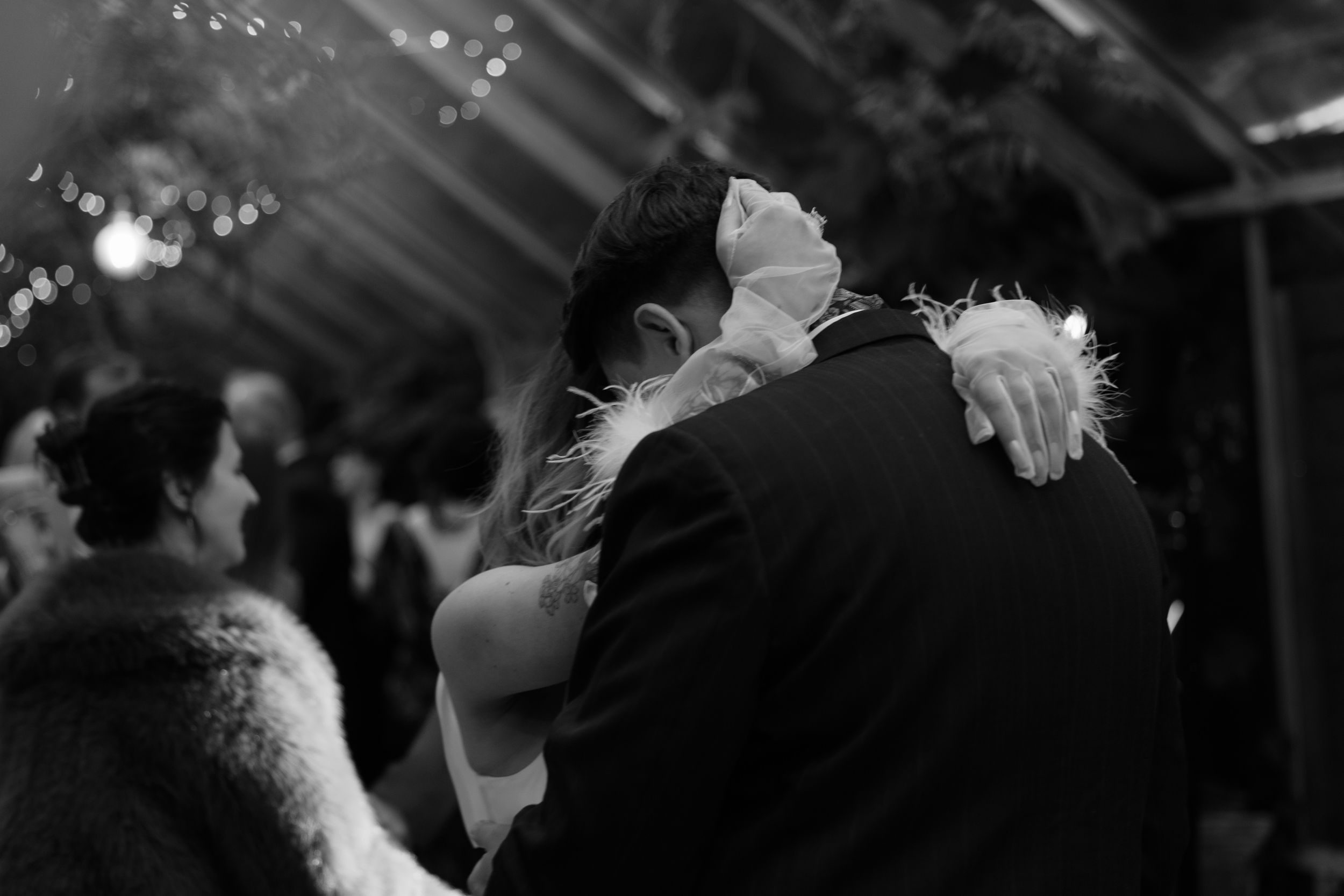 A romantic black and white candid moment captured at a wedding reception during a slow dance.