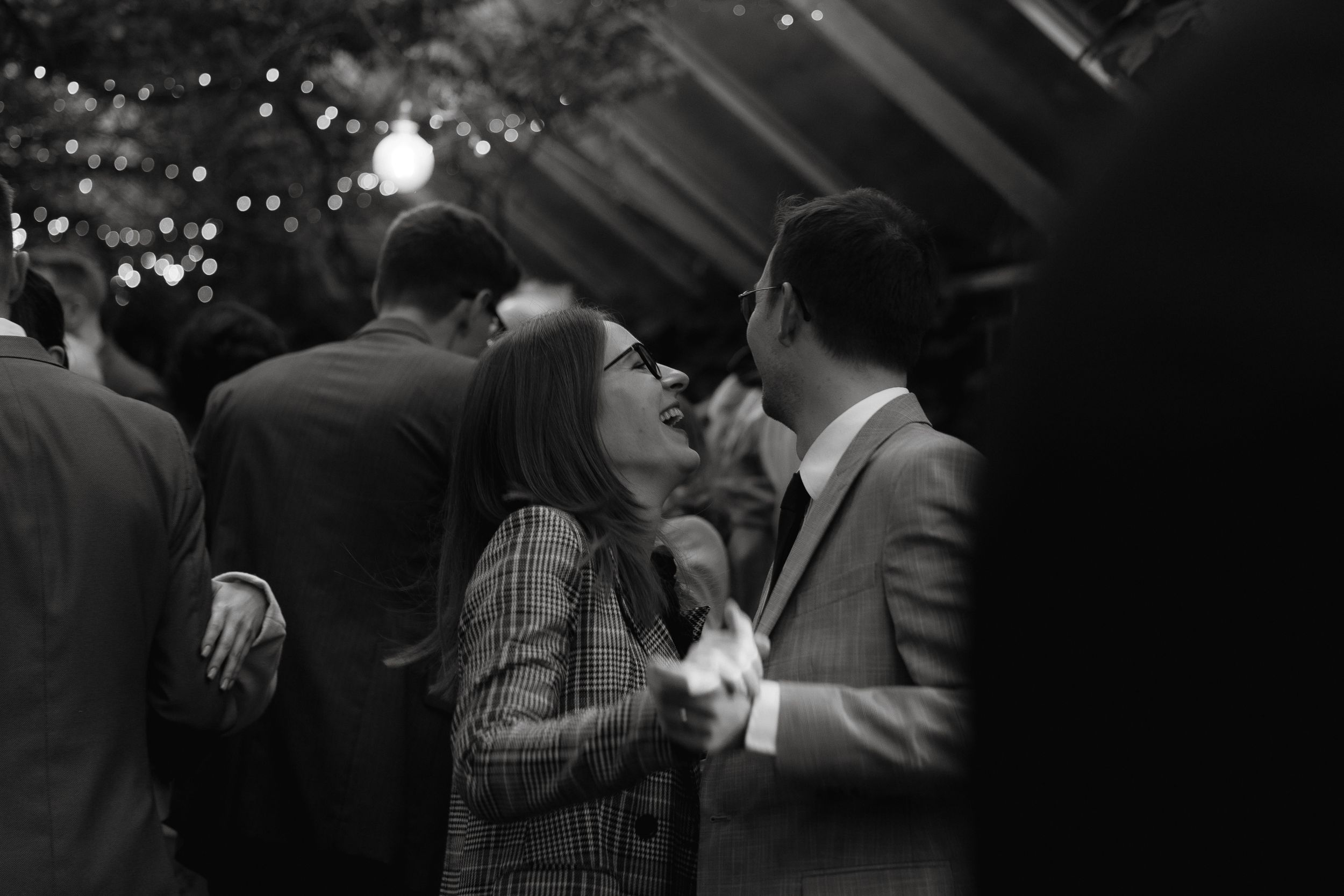 A couple shares a romantic moment on a dance floor with twinkling lights in the background.