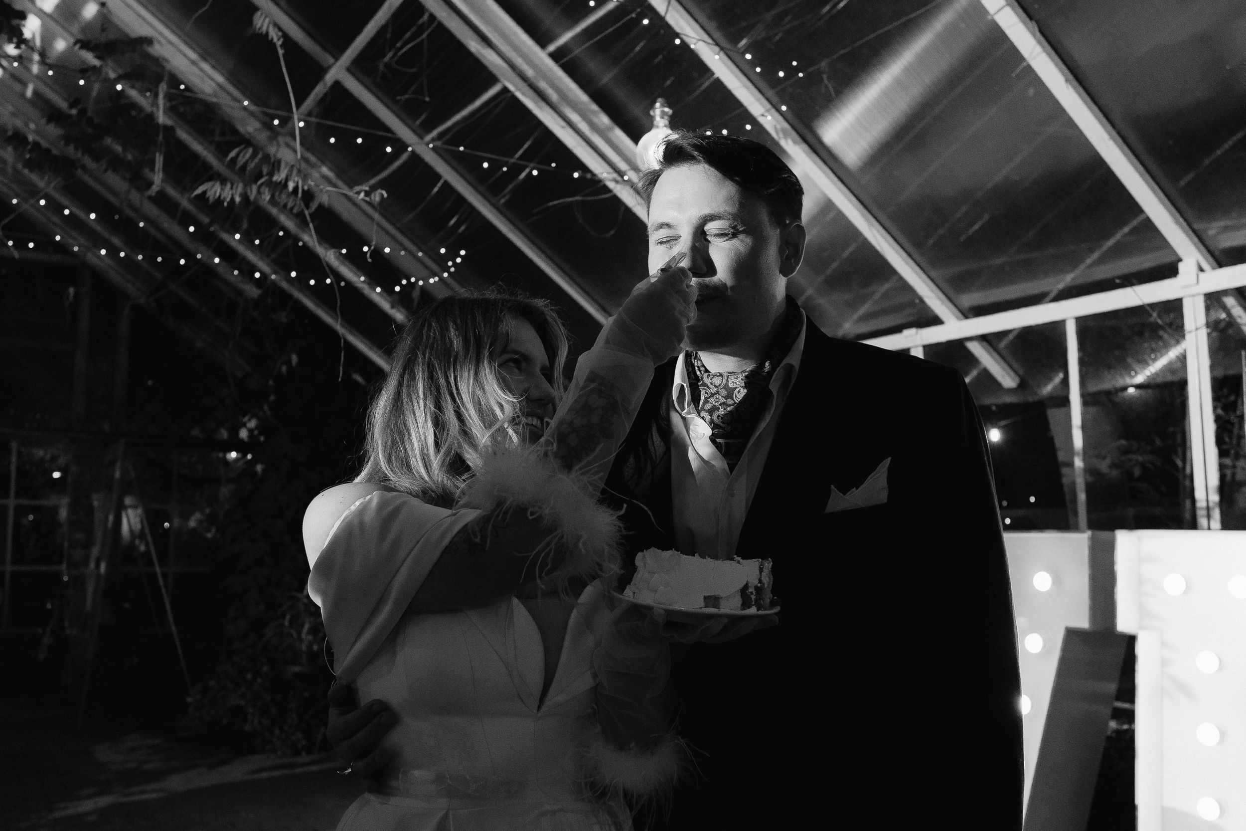 Energetic dancing and celebration under twinkling lights at an indoor wedding reception.