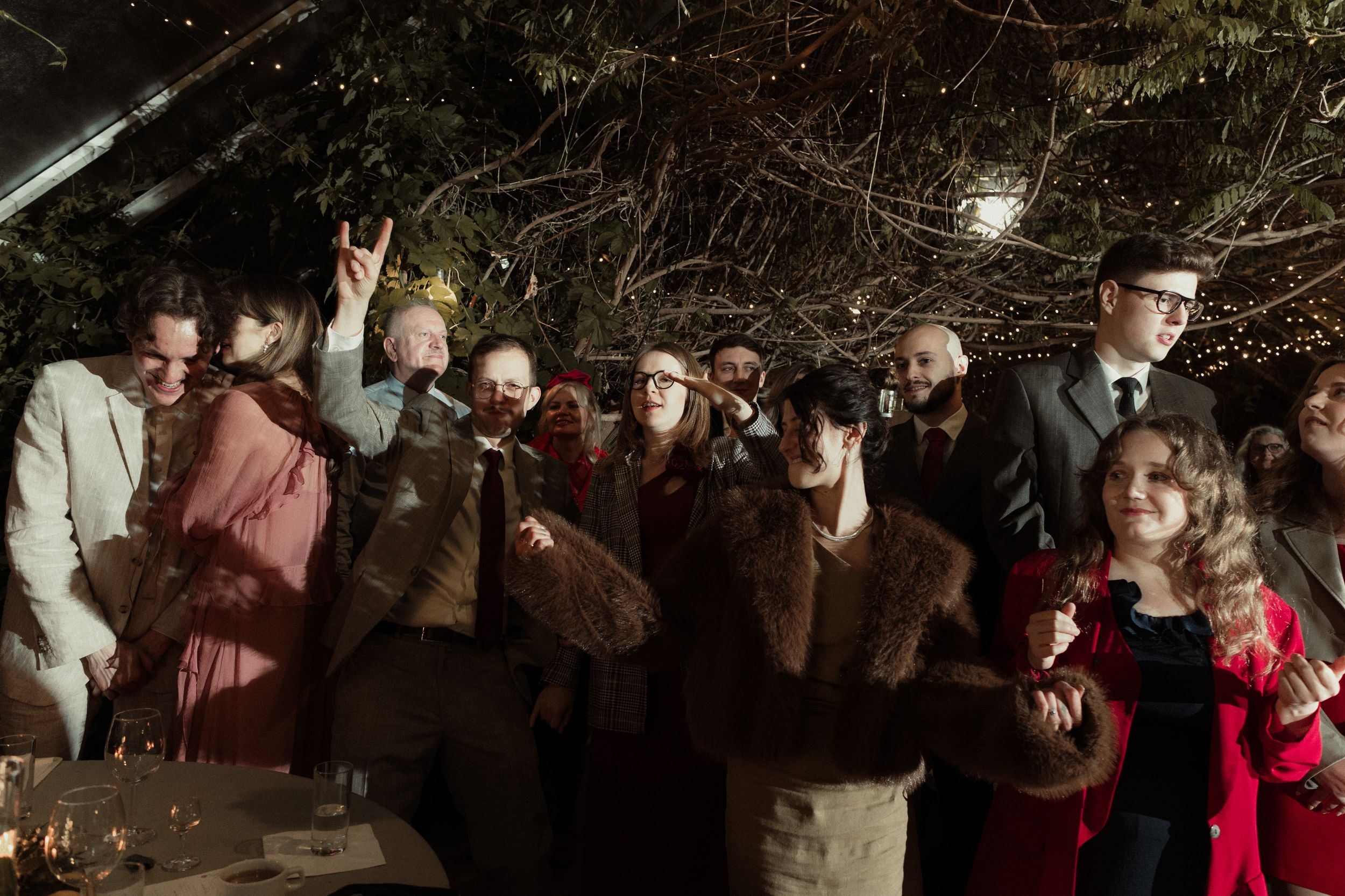 Large crowd of wedding guests gathered on dance floor during evening celebration.