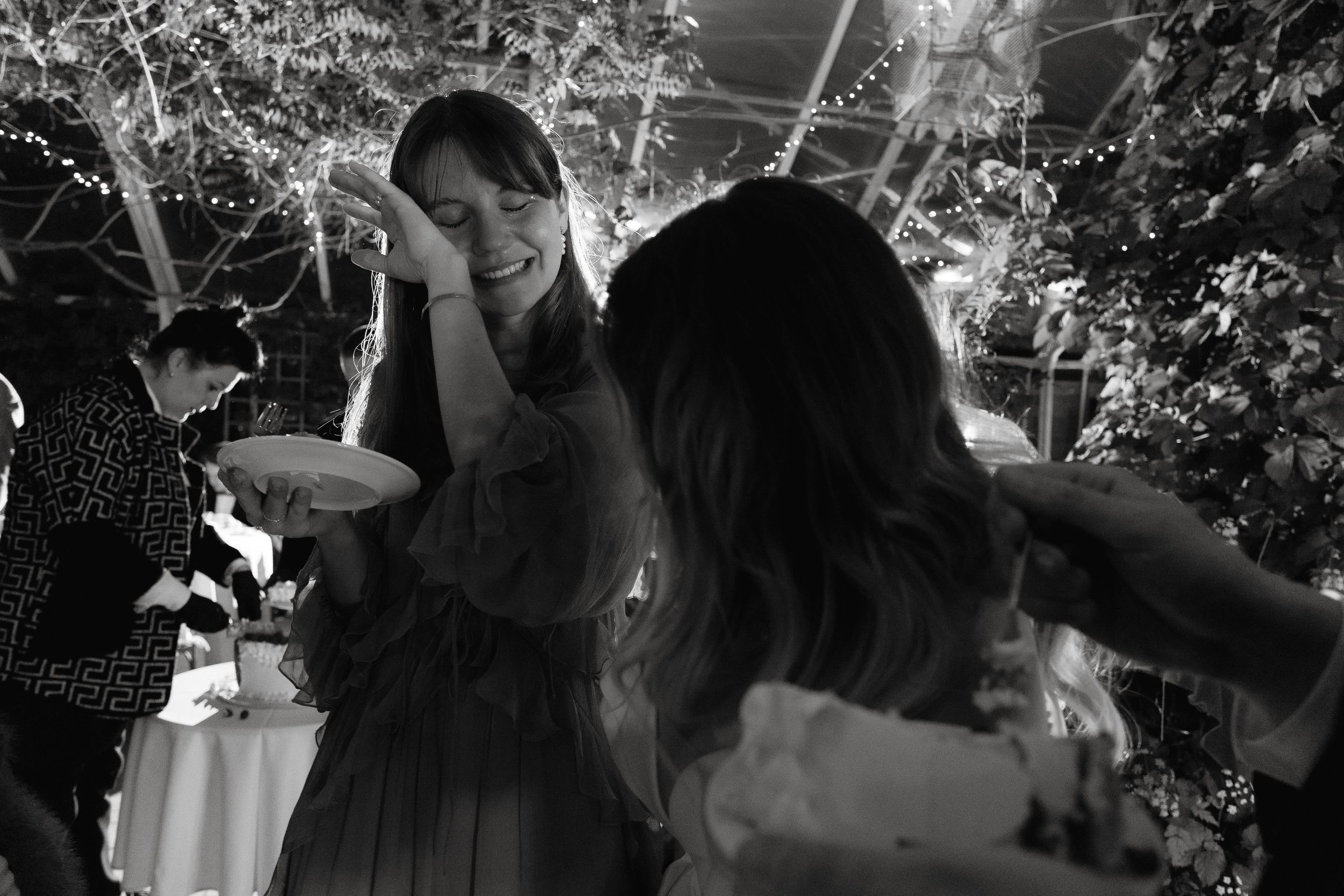 Black and white photo of guests dancing and celebrating at a nighttime party.