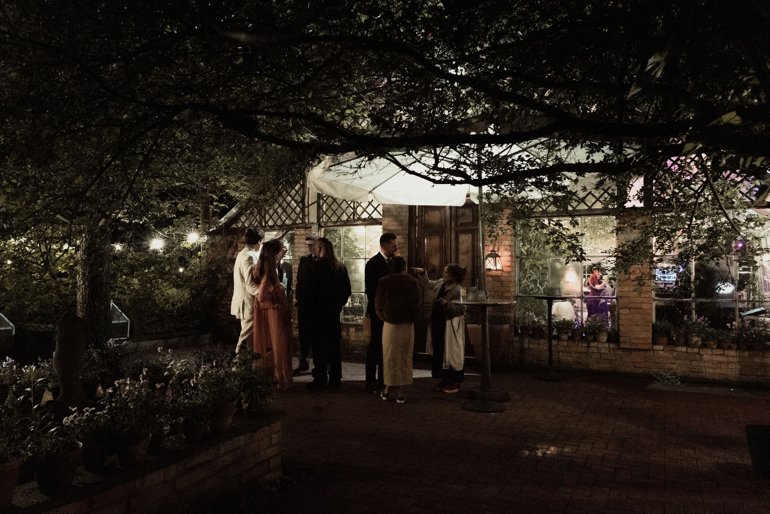 Outdoor nighttime venue illuminated by string lights and lanterns creating a magical ambiance.