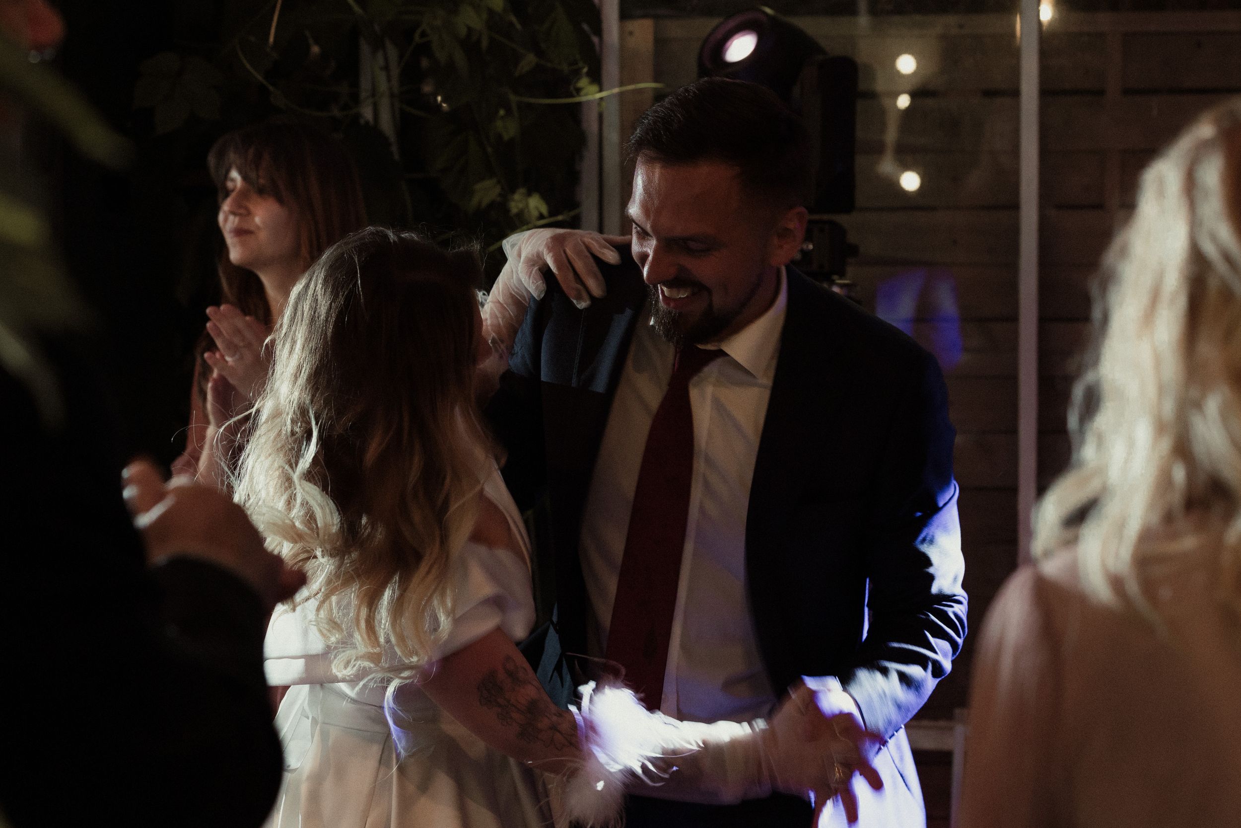 A couple dances together on a dimly lit dance floor during a romantic celebration.