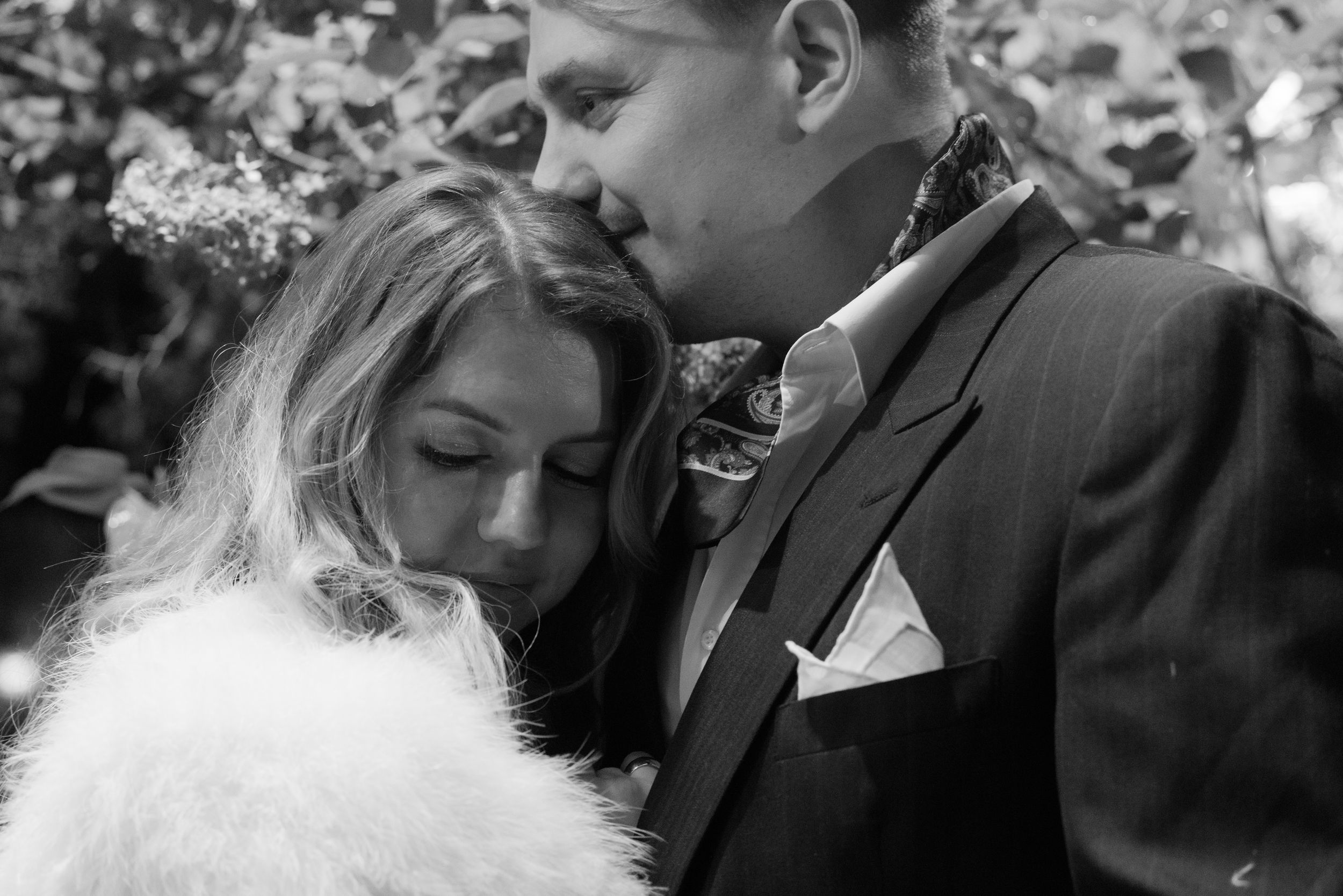A romantic black and white wedding photo sequence showing tender moments between newlyweds.
