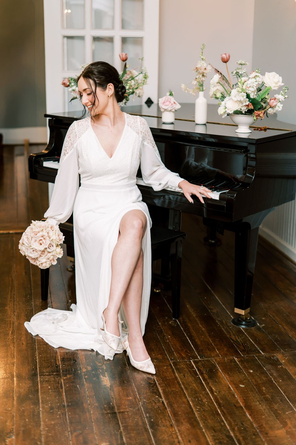 A bride poses with a piano in a historic house turned wedding venue in Holly Springs NC, photo by Fayetteville NC Wedding photographer