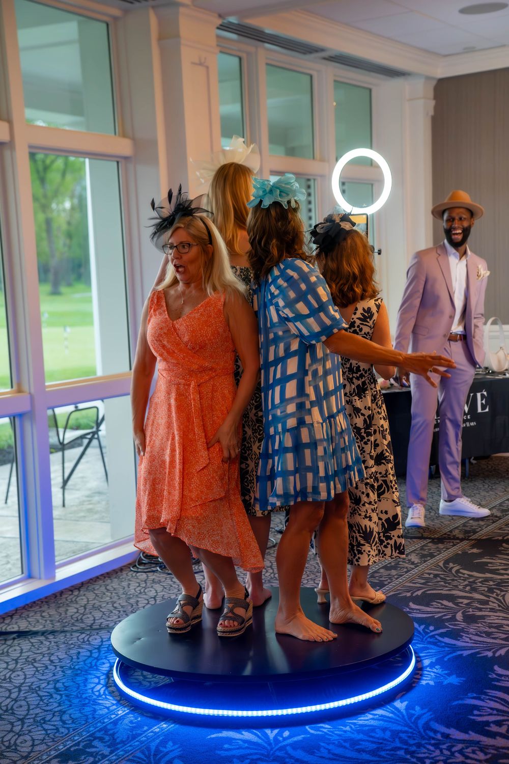 People dancing on an illuminated blue circular platform at a party.