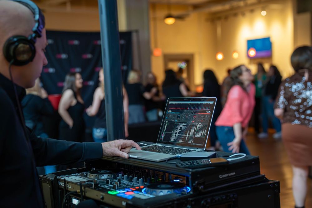 DJ booth and equipment setup at an indoor venue with ambient lighting.