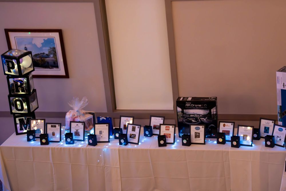 Row of framed photographs displayed along a beige wall in an event space.