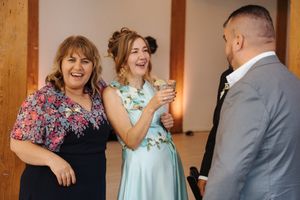 Wedding guests in formal attire share joyful moments during a reception celebration.