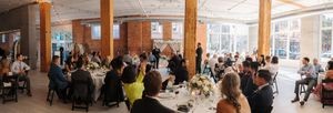Panoramic view of a modern cafeteria with exposed brick walls and large windows filled with dining guests.