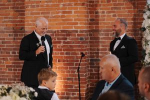 Wedding guests gathered in a rustic brick-walled venue during a celebration event.