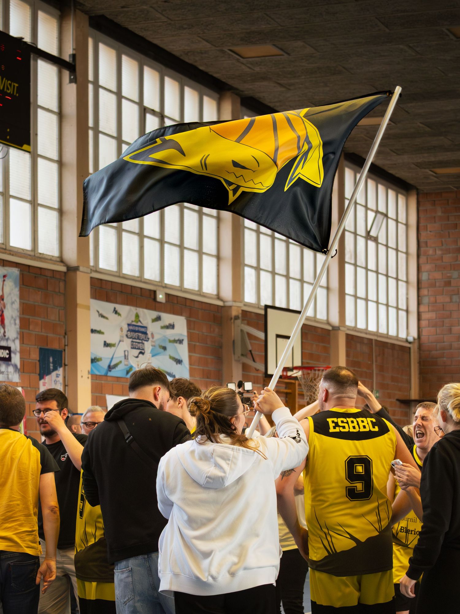 Public d'une équipe de basket noir et jaune fêtant une victoire sur la Côte d'Opale