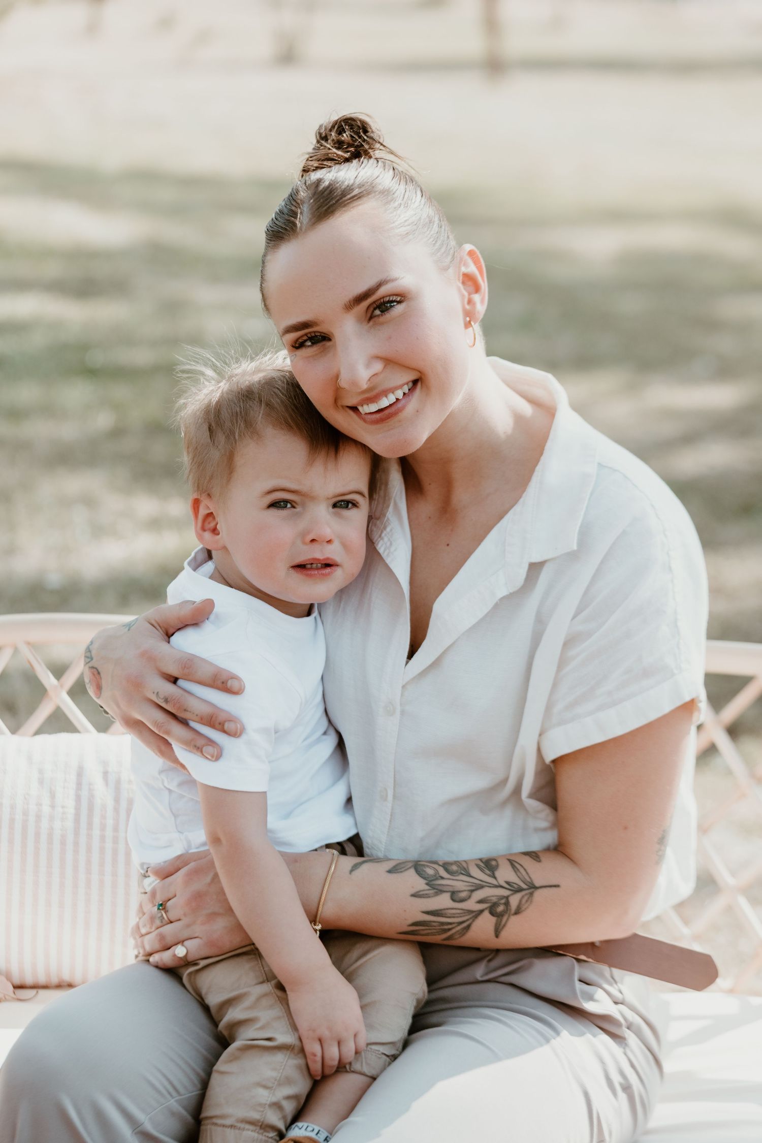 Heartwarming outdoor portrait session showing tender moments between parent and child on white furniture.
