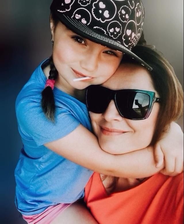 Affectionate moment captured with bright blue shirt and sunglasses.