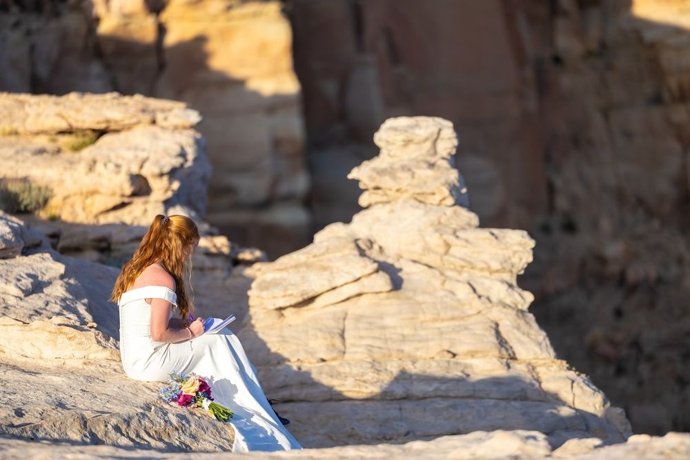 Group of visitors exploring ancient ruins and rock formations along a coastal landscape during sunset.