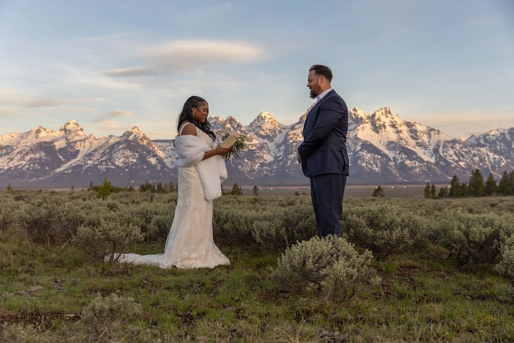 Wedding couple shares intimate moments at sunset with the majestic Grand Teton mountains creating a stunning backdrop.