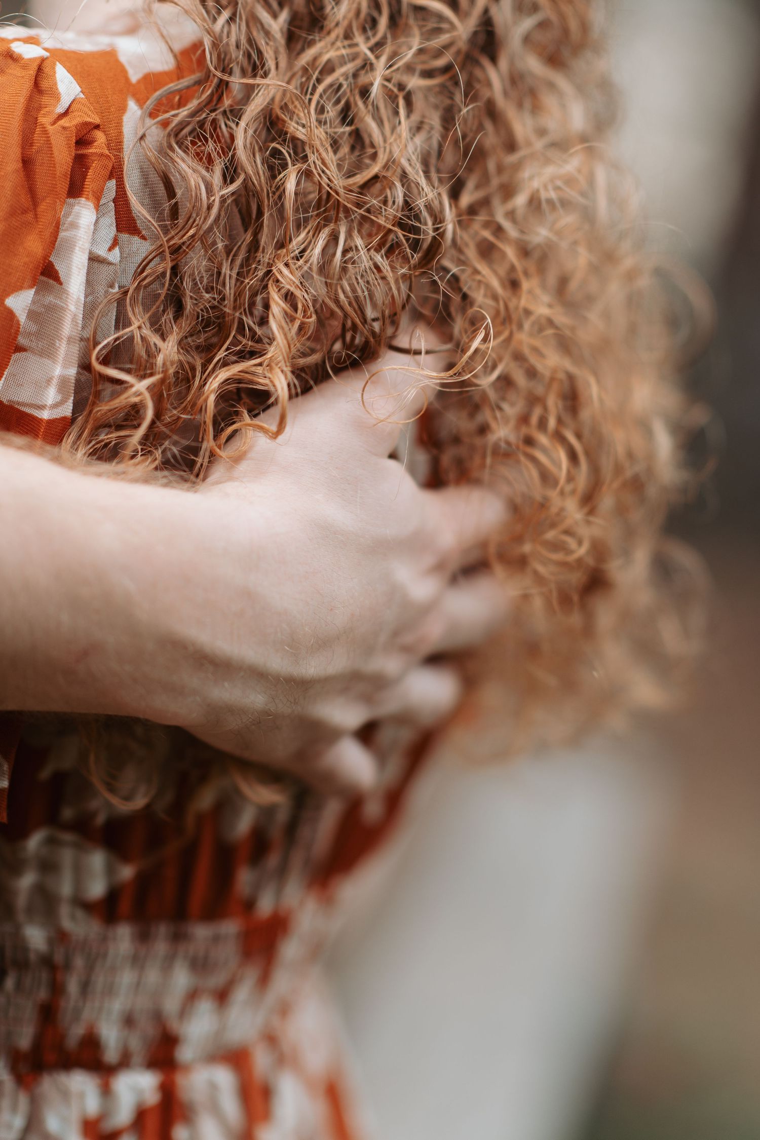 Mans hand tangled in his fiances red hair during an engagement session in Post Falls Idaho at Kiwanis Park.