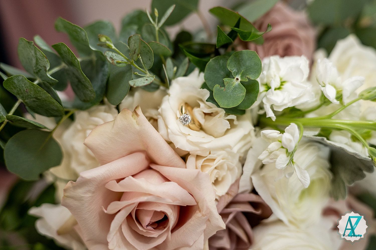 Elegant floral bouquet features blush pink roses and white blooms with lush greenery in a romantic garden arrangement.