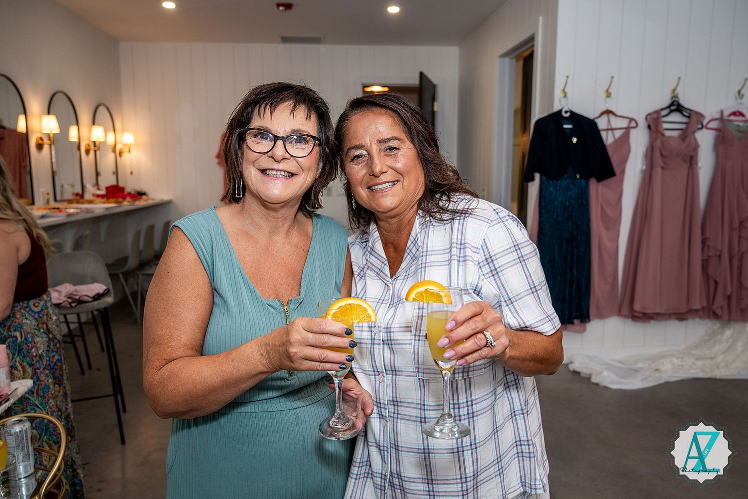 Wedding party members toasting with drinks during pre-ceremony celebrations.