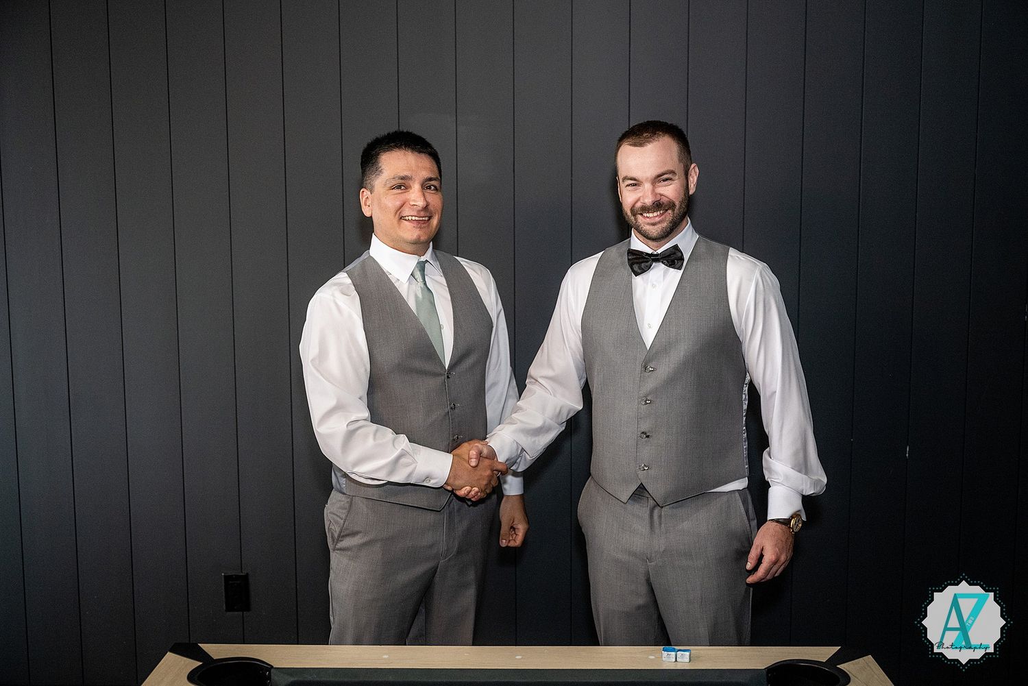 Groomsmen in matching gray vests and white shirts posing together for formal wedding photos.