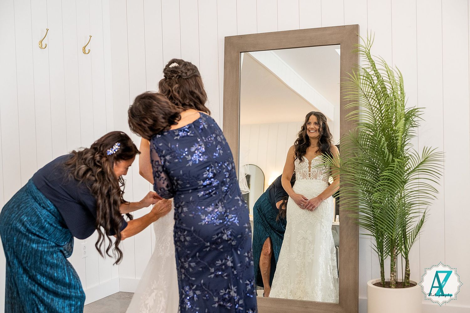 Wedding photographer taking photos of bride in white dress and bridesmaids in navy dresses.